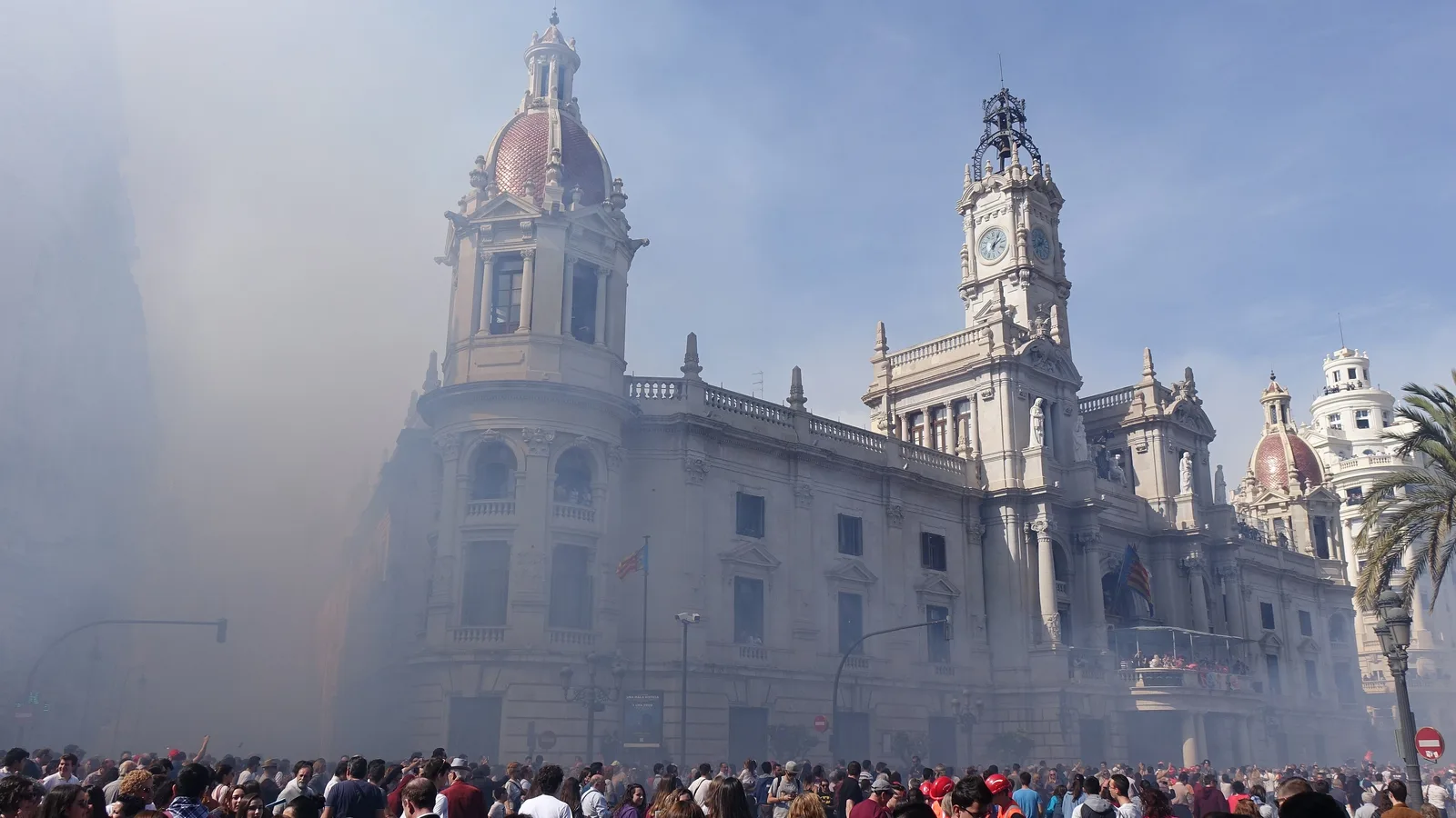 Mascleta firework burst with billowing smoke over a crowd silhouette in Valencia