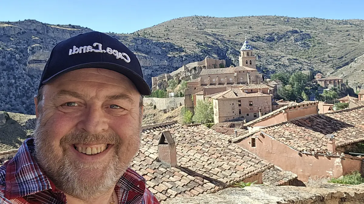 Michael Bastin, fundador de ValenciaMove, sonriendo en Albarracín con los tejados, la torre de la catedral y el castillo detrás
