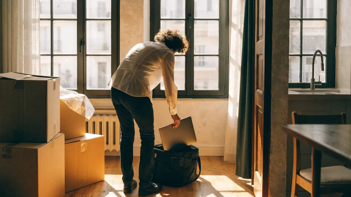 Professional pakt een laptop uit in een licht nieuw appartement in Valencia