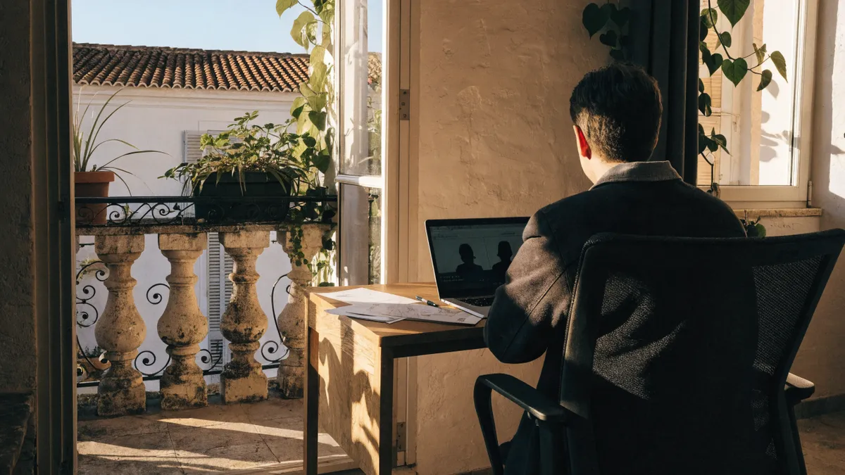 Remote worker on a video call at home near a bright Valencia balcony
