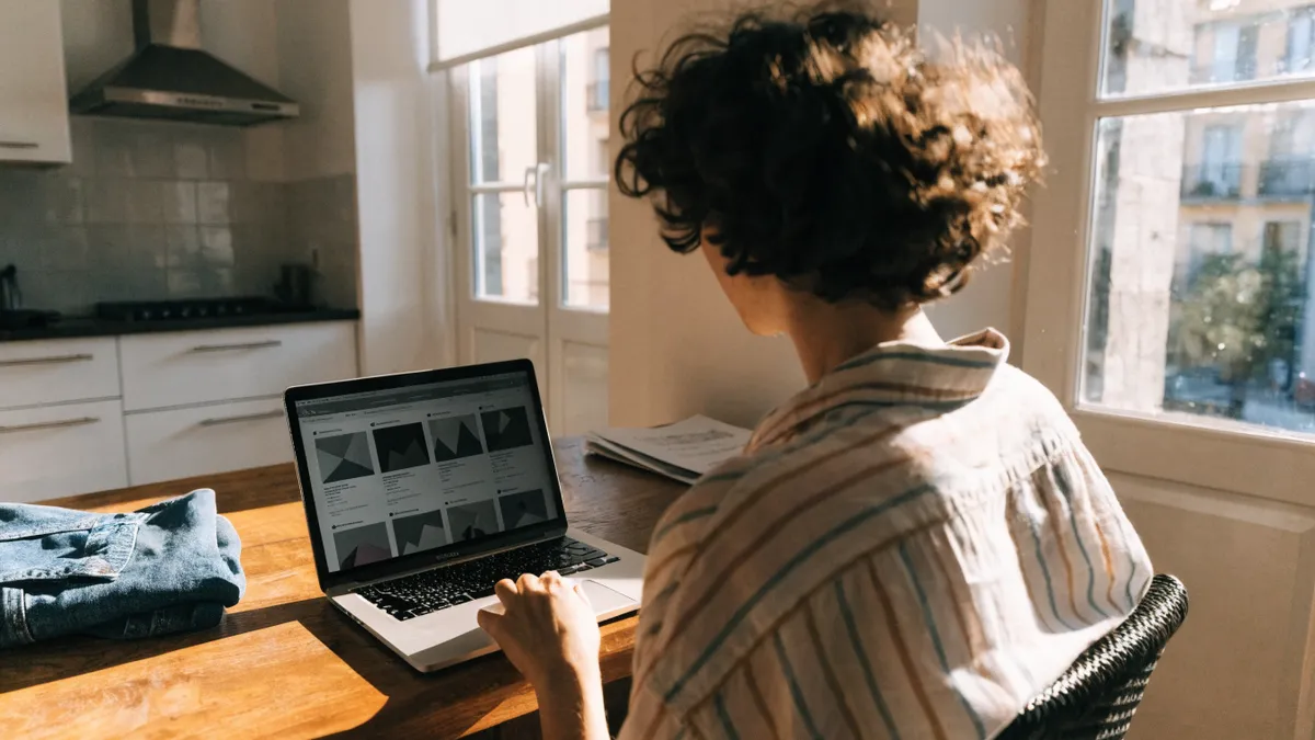Consultation d'annonces d'appartements sur un ordinateur portable dans un appartement lumineux de Valencia