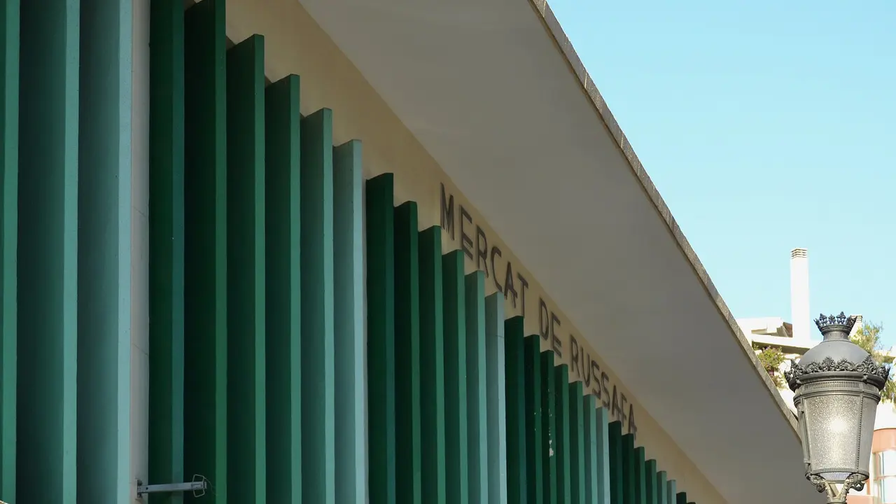 De groene gevel van de overdekte markt Mercat de Russafa in de wijk Ruzafa in Valencia onder een heldere lucht