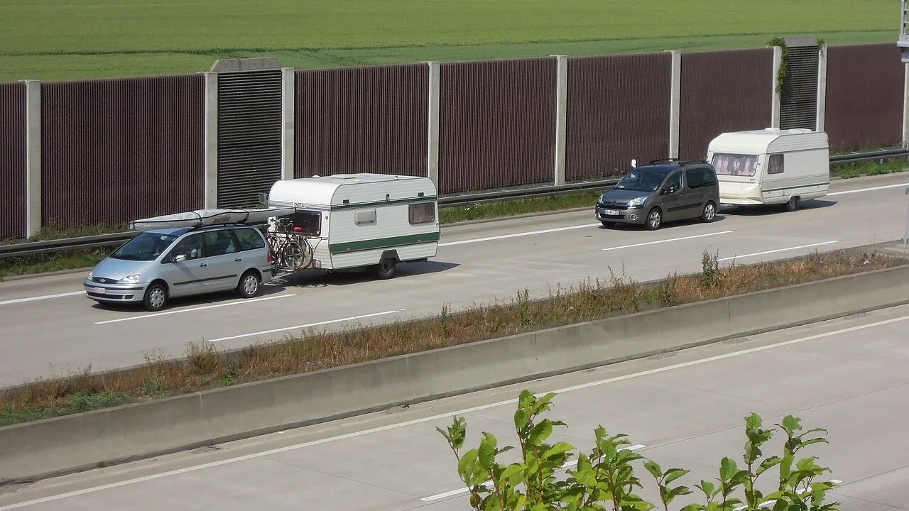 Twee caravans die door auto's worden getrokken op een Duitse snelweg, ter illustratie van vervoer van een voertuig over de weg