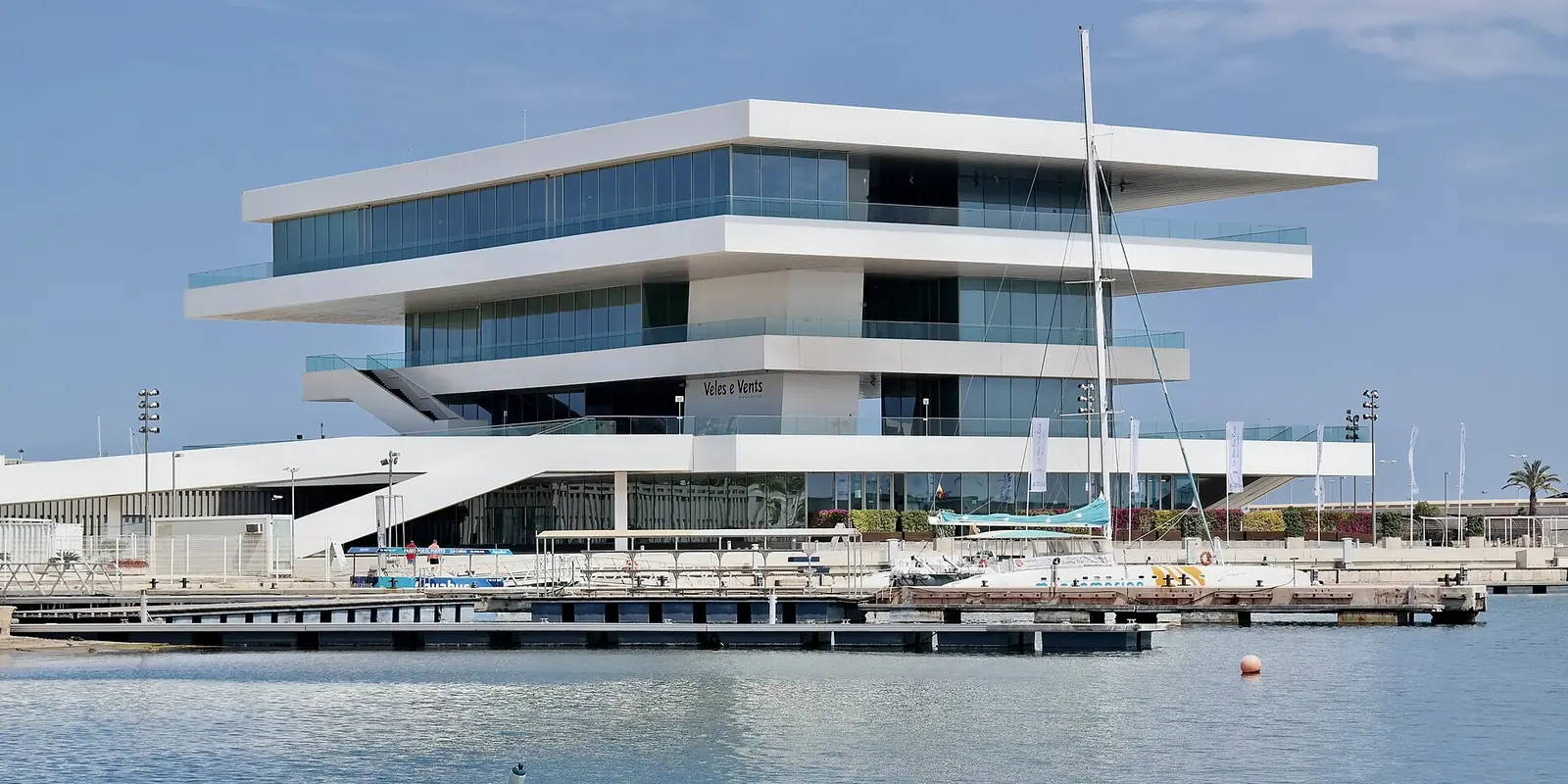Het witte, uitkragende gebouw Veles e Vents, gezien over het water van de Marina de València