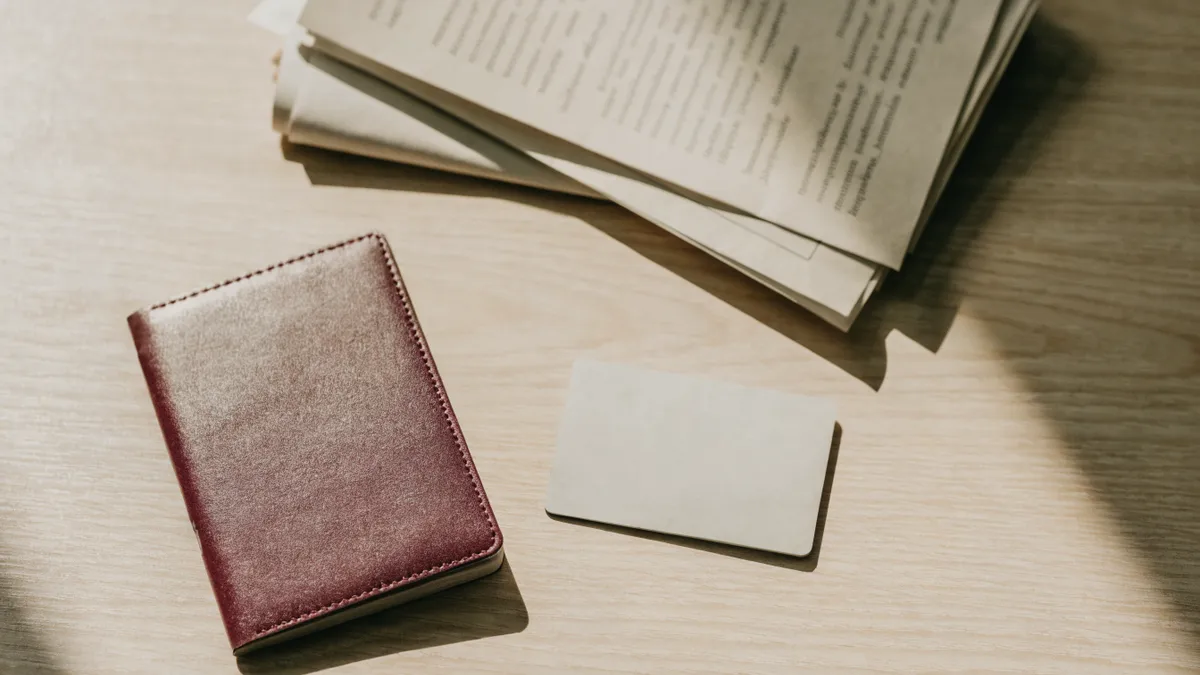 Pasaporte, tarjeta bancaria y documentos dispuestos sobre un escritorio