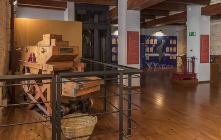 Machinerie en bois restaurée pour la mouture du riz et panneaux explicatifs à l'intérieur du musée du riz du Cabanyal, à Valencia