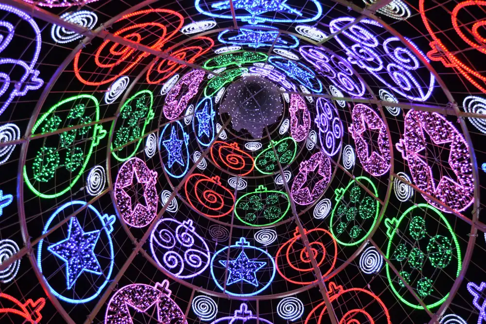 De binnenkant van de reusachtige kerstboom van lichtjes op de Plaça de l'Ajuntament in Valencia, gekleurde sterren en spiralen tegen de nacht