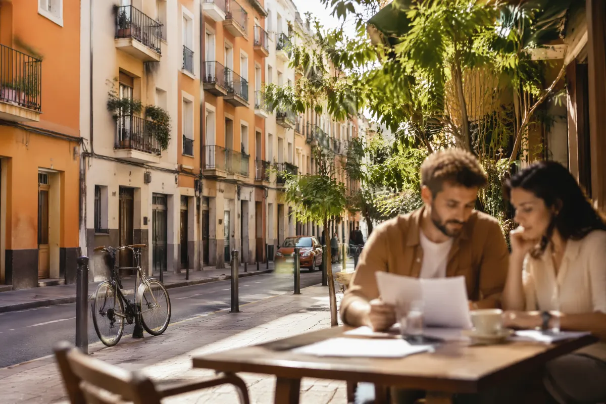 Un couple consultant des documents à la terrasse d'un café dans une rue de Valencia