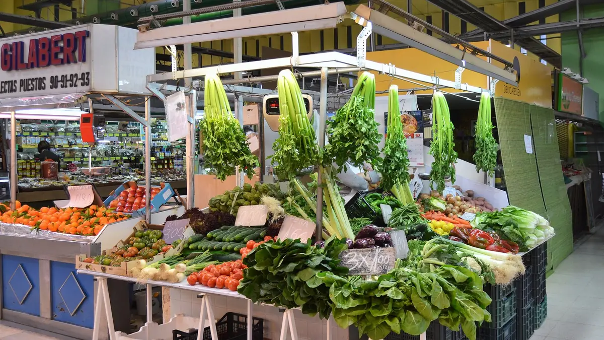 Un étal de primeur au Mercat de Russafa à Valencia, chargé de blettes, de céleri, de tomates et de poivrons