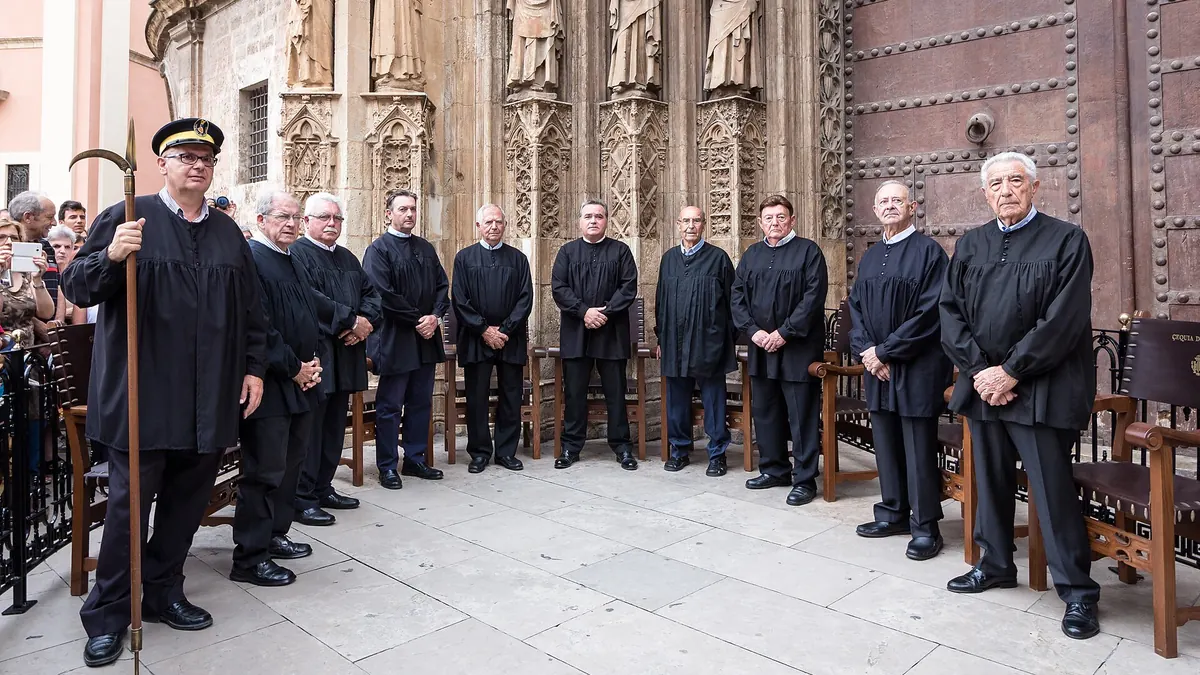 Les membres du Tribunal de les Aigües en blouse noire devant la Porta dels Apòstols de la cathédrale de Valencia