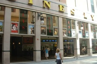 Street-level facade of Cines Lys with film posters in the windows