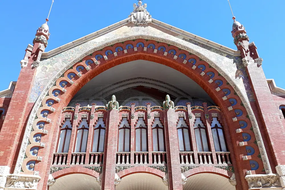 The modernist brick and ceramic arch of the Mercat de Colom facade in Valencia