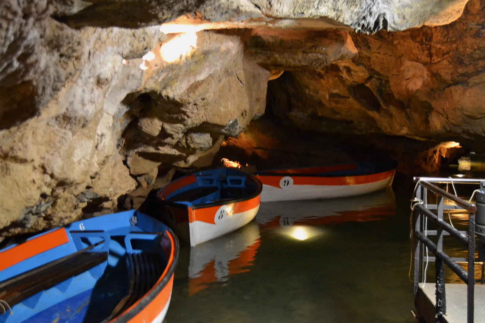 Des barques en bois numérotées amarrées à l'embarcadère sur la rivière souterraine, à l'intérieur des Coves de Sant Josep