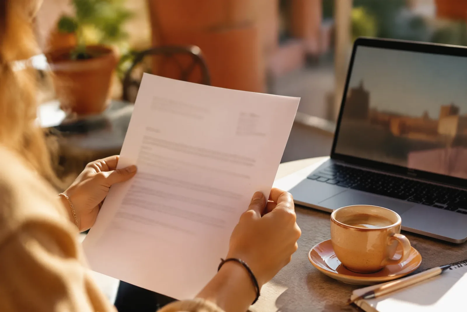 Una carta de concesión de beca Erasmus sobre la mesa soleada de un café en Valencia