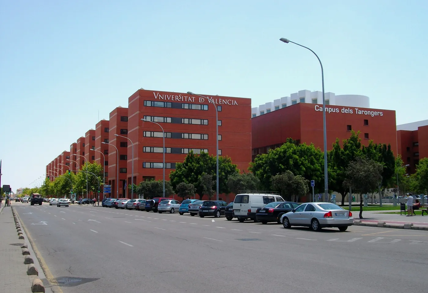Les bâtiments de faculté en brique rouge de l'Universitat de València sur le campus de Tarongers, alignés le long d'une large avenue