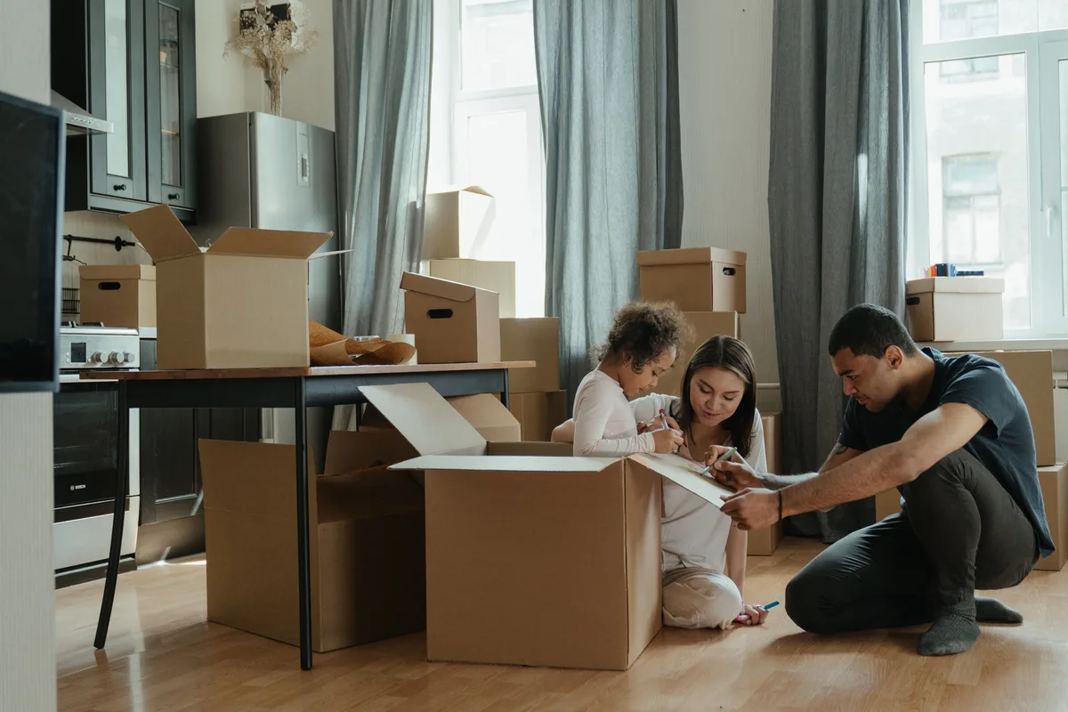 Una familia desempacando cajas juntos en su nuevo hogar