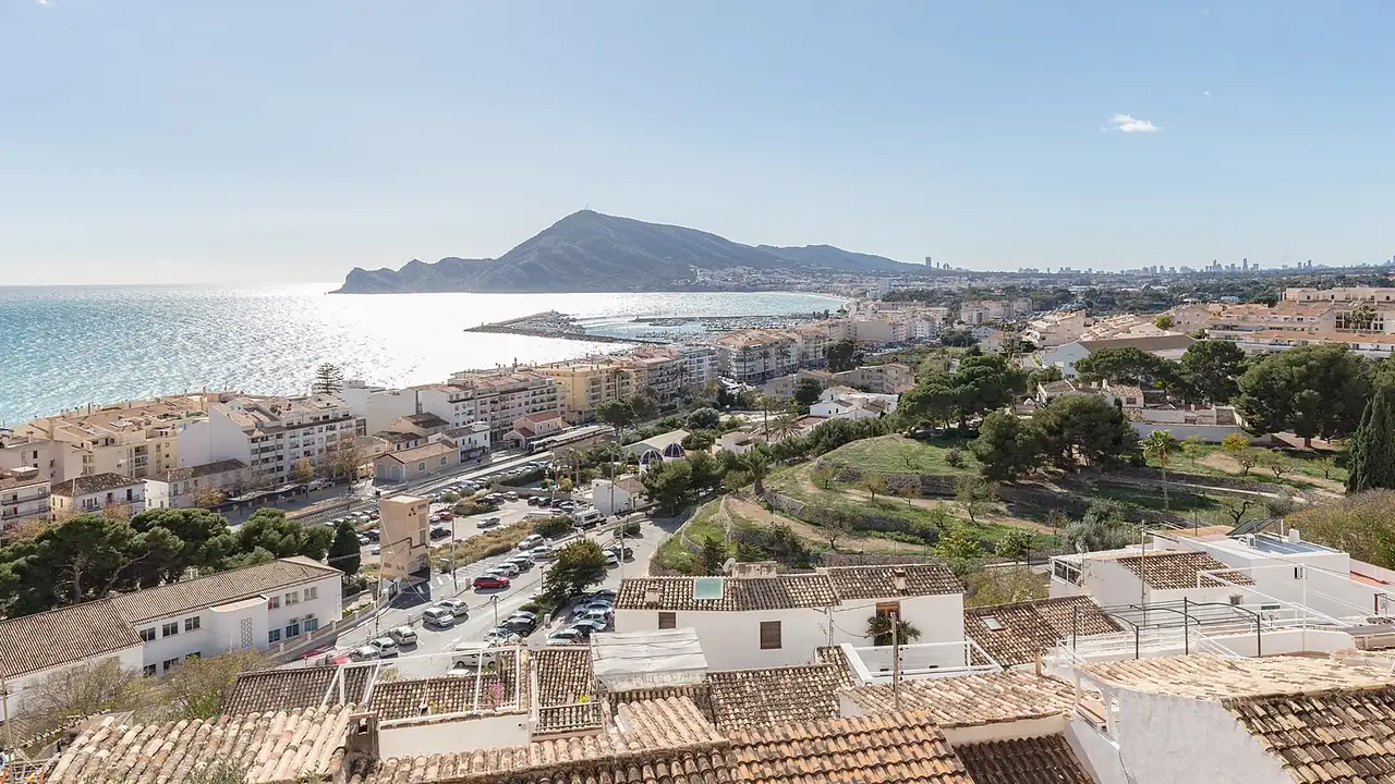 Vue sur les toits d'Altea vers le front de mer, le port de plaisance et la Serra Gelada, avec les tours de Benidorm au loin