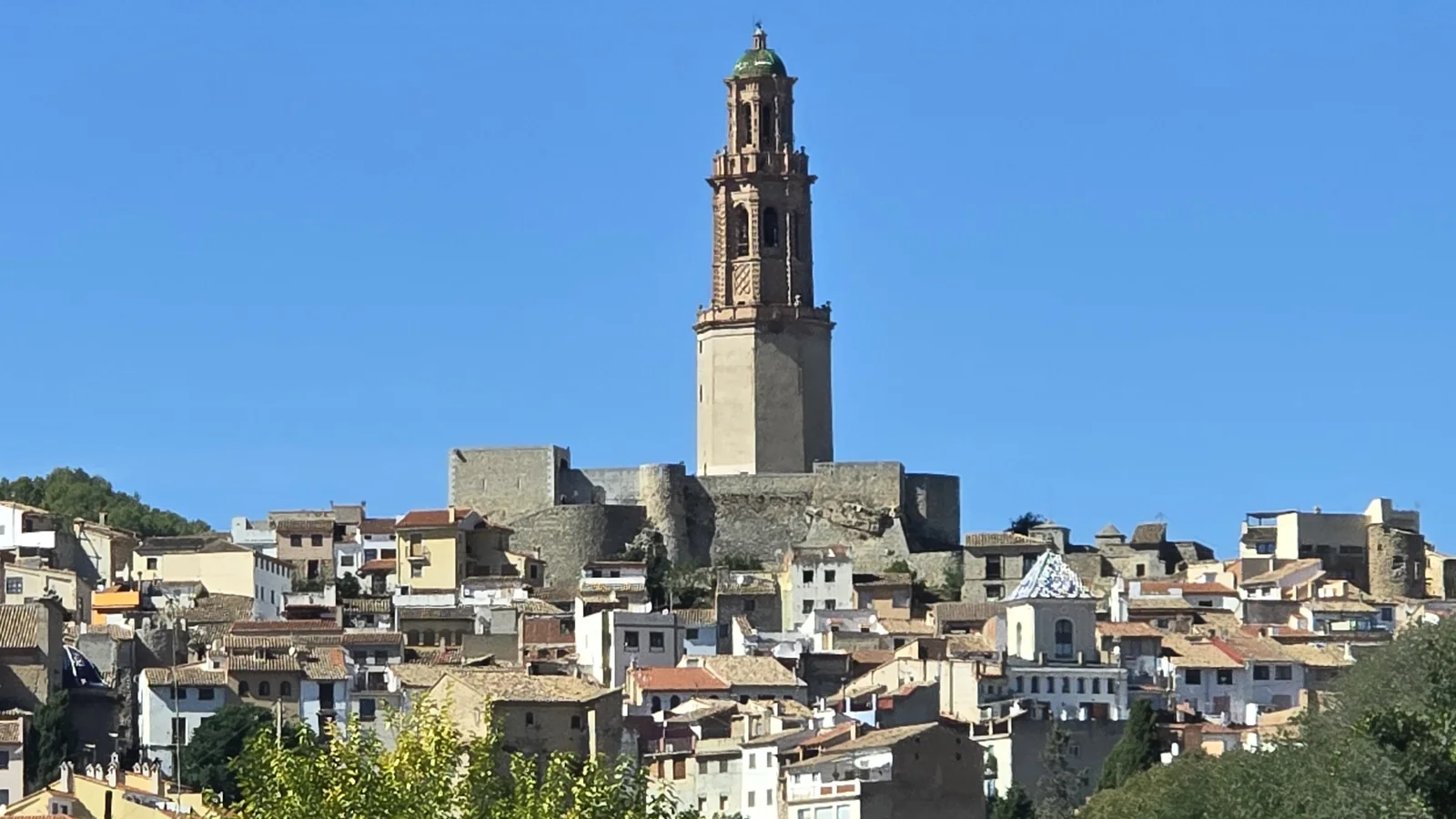 Jérica old town climbing its hill, with the brick Mudéjar bell tower and the castle walls at the top