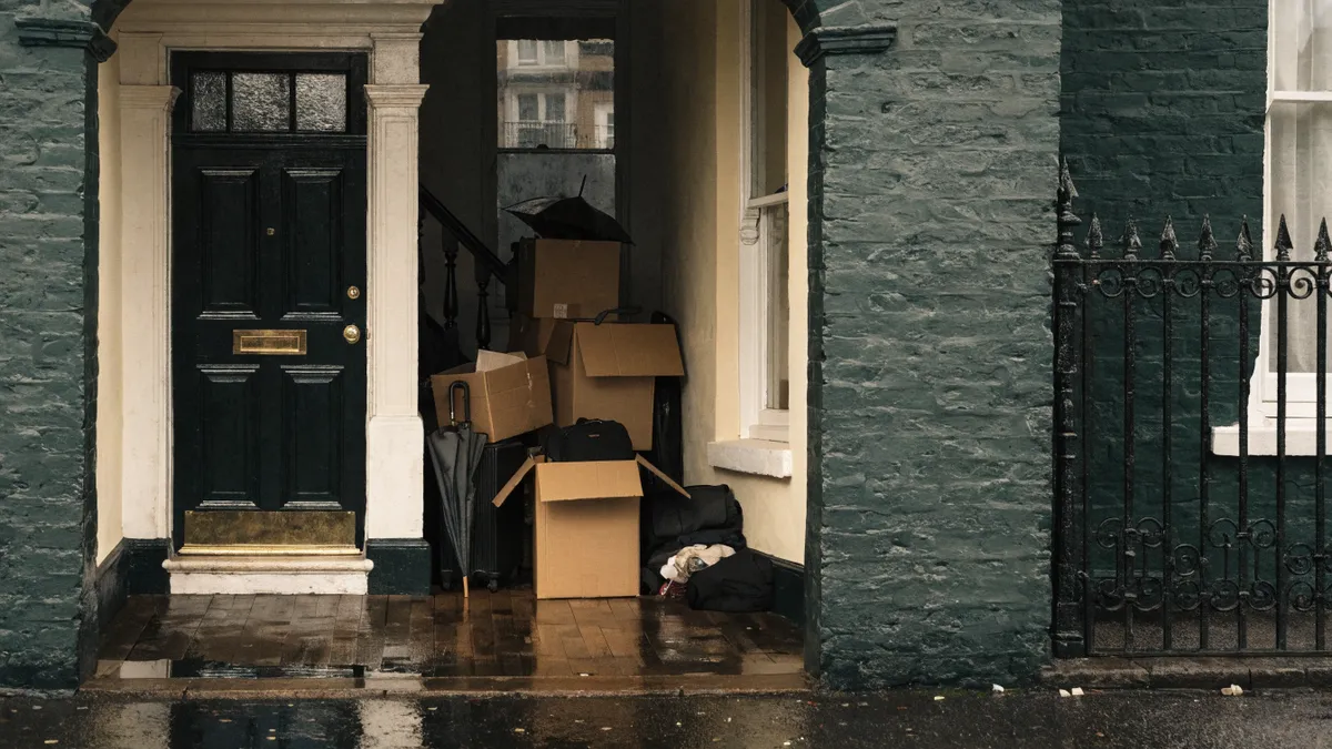 Moving boxes and suitcases in the hallway of a British terraced house on a rainy day