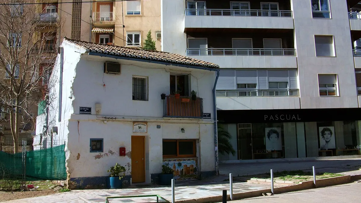Maison blanchie à la chaux à deux niveaux et toit de tuiles sur le Camí Vell de Benimaclet, entre des immeubles modernes à Jaume Roig, Valencia