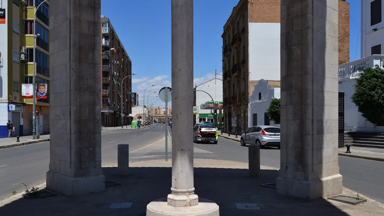 Les piliers de pierre et le fût de la croix du monument de la Creu Coberta, avec la Carrer de Sant Vicent Màrtir en perspective, à La Creu Coberta, Valencia
