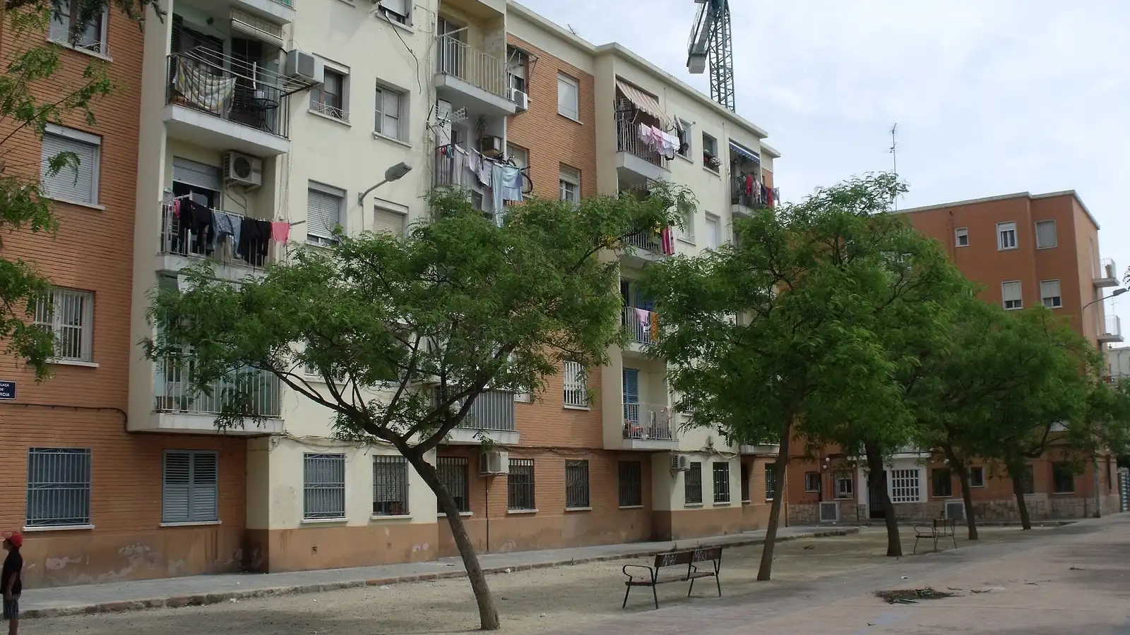 Des immeubles de quatre niveaux bâtis pour les familles sinistrées de la crue de 1957, autour d'une place piétonne arborée à La Fontsanta, Valencia