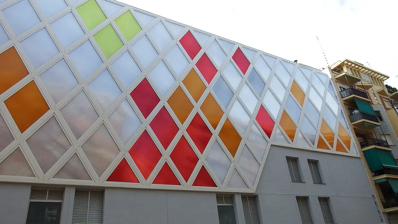 Un bâtiment à la façade de losanges translucides colorés entre la Carrer de Luis Lamarca et la Carrer de Torres à Nou Moles, Valencia