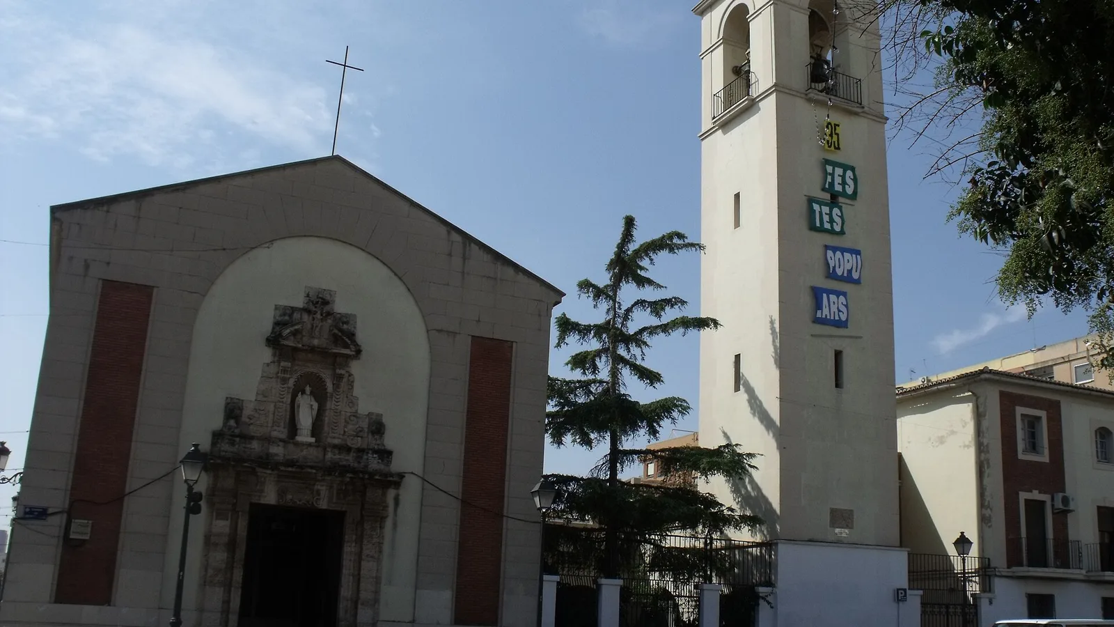 L'église paroissiale de Sant Marcel·lí Bisbe et son clocher orné de banderoles de fête, à Sant Marcel·lí, Valencia
