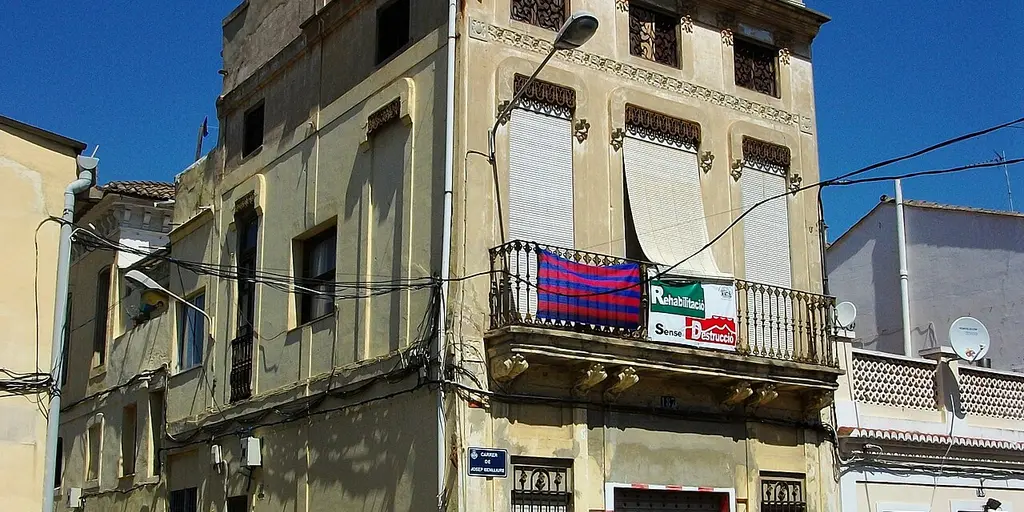 Une maison d'El Cabanyal avec une banderole « Rehabilitació sense destrucció » au balcon