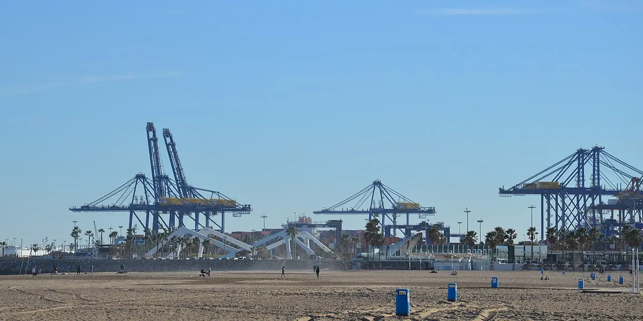 Container cranes at the Port of Valencia seen from the beach