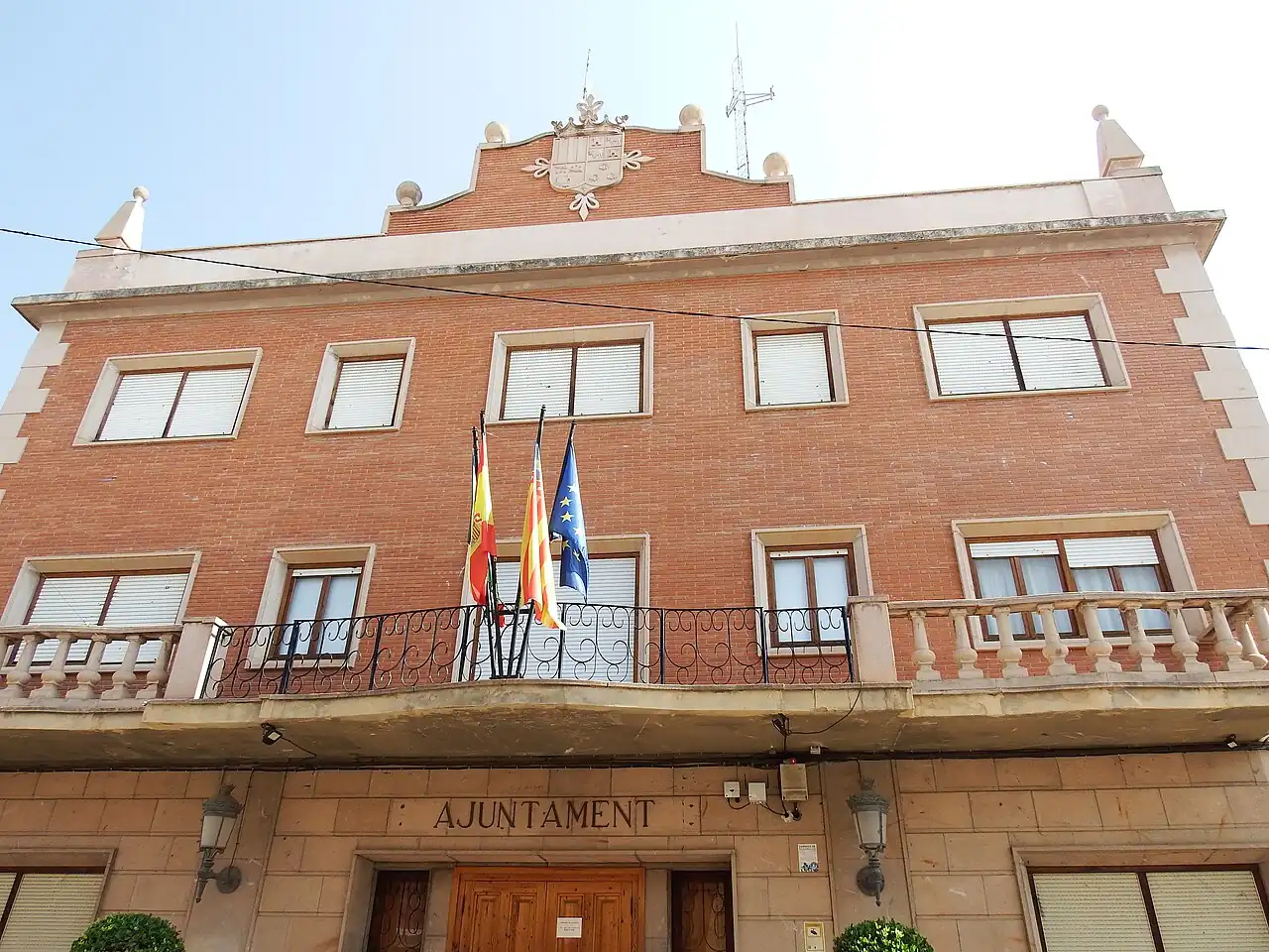 The red-brick town hall of Bétera, with its balcony, flags and the word Ajuntament above the door