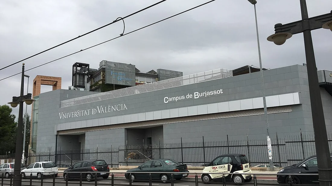 El edificio del Campus de Burjassot de la Universitat de València visto desde la línea del tranvía, con el cartel de la Facultad de Química en la azotea