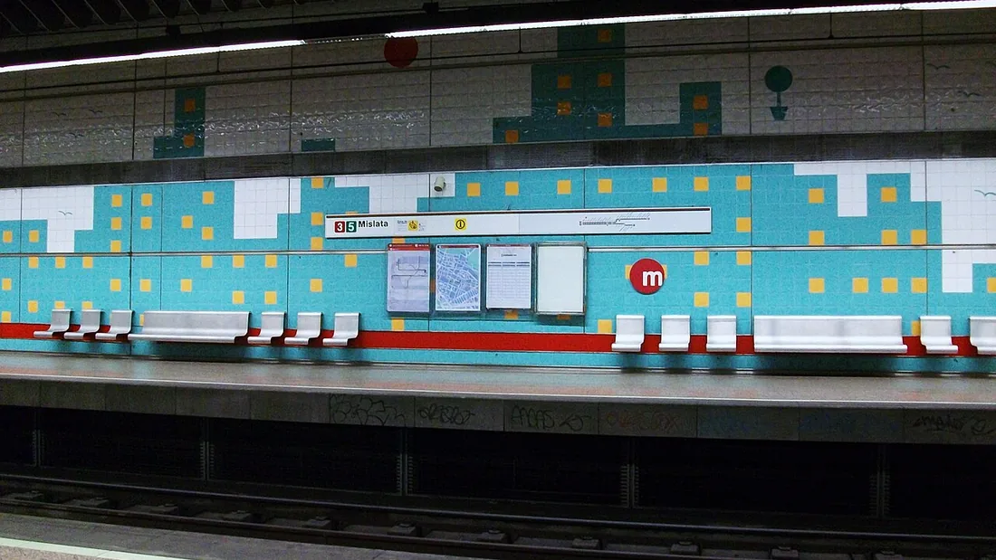 Andén de la estación de metro de Mislata, con paredes de azulejos turquesa y amarillos y un cartel con las líneas 3 y 5