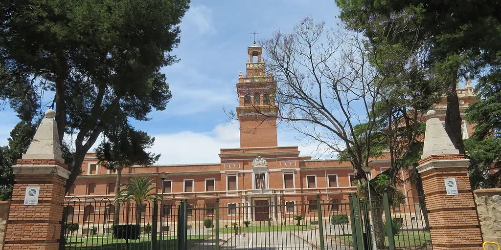 The brick Seminario Metropolitano de Valencia in Moncada, with its tall central tower, seen through the entrance gates