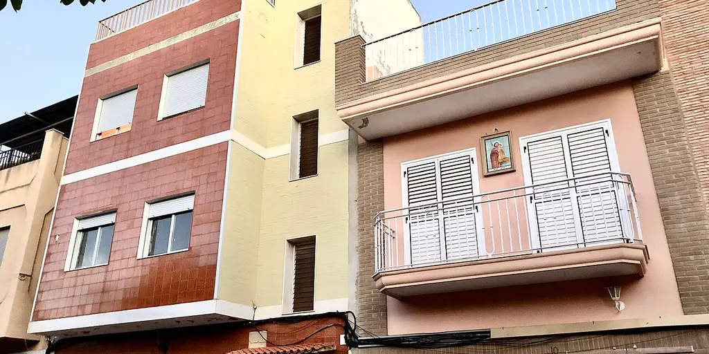 Brick and tiled apartment houses with small balconies on the Placa de Sant Josep in Rafelbunyol