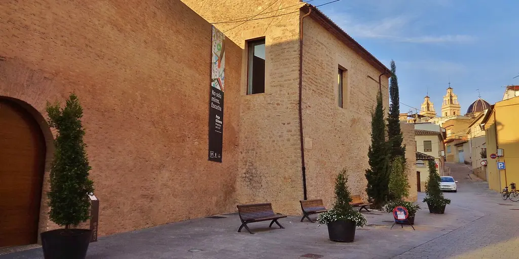 The old castle walls of Riba-roja de Turia, with a church bell tower rising behind them