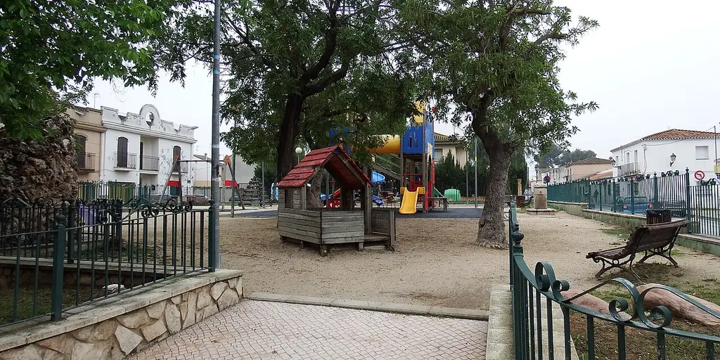 A children's playground under trees in a small park in San Antonio de Benageber