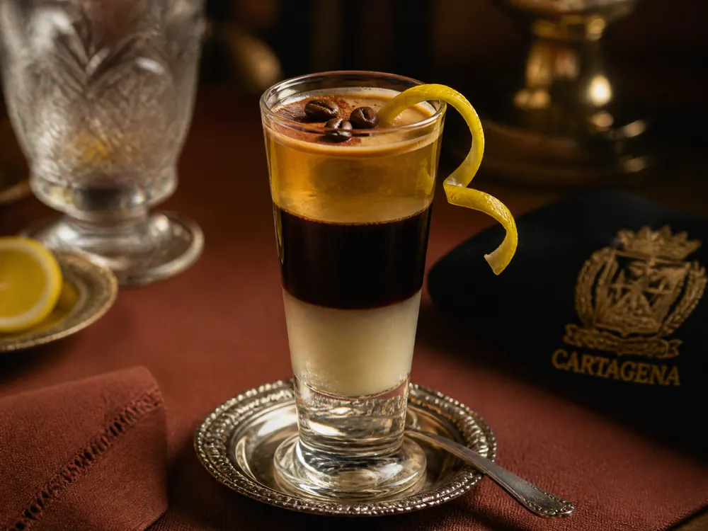 Café asiático uit Cartagena: gelaagde gecondenseerde melk, koffie en Licor 43 of brandy, met citroenschil en kaneel