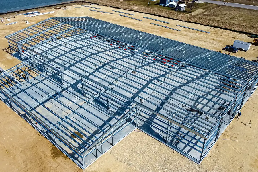 Aerial view of a steel-framed building under construction, beams and joists forming a visible structural grid