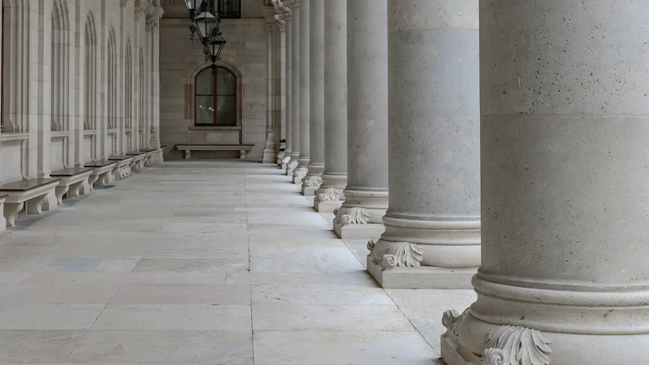 Een zonnige colonnade van witte stenen zuilen op een historische universiteitscampus
