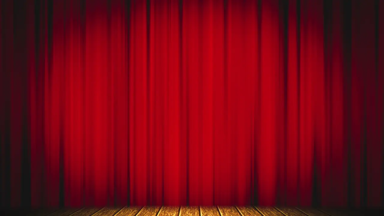A rich red stage curtain above a wooden theatre stage