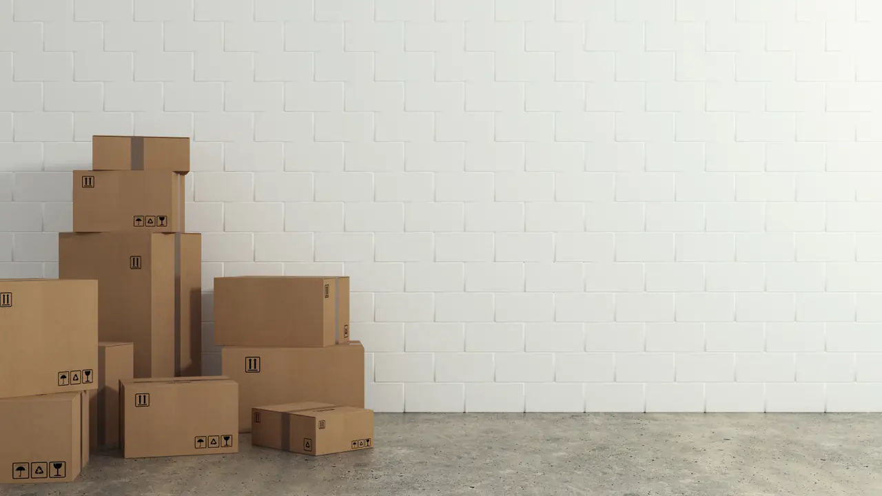 Gestapelde kartonnen verhuisdozen tegen een muur, ingepakt voor een internationale verhuizing
